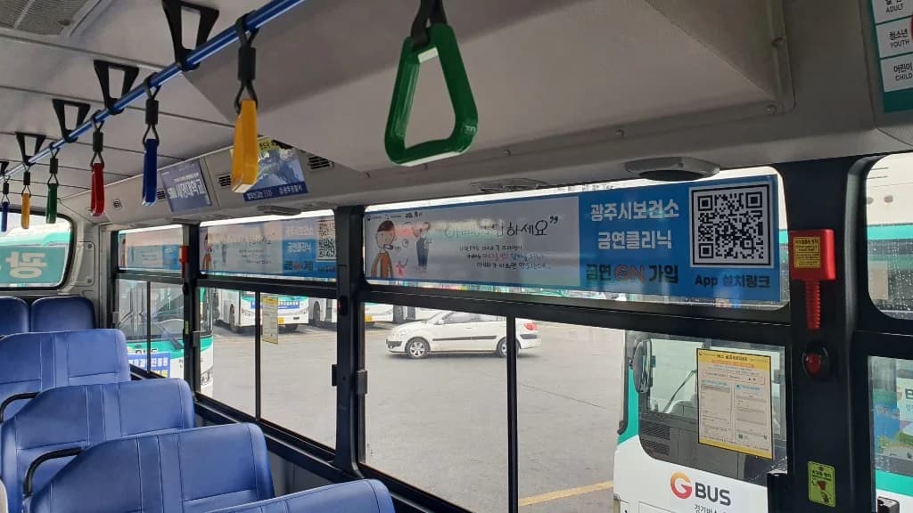 시내버스 내부 손잡이 위 광고판에 부착된 금연클리닉 QR 홍보물